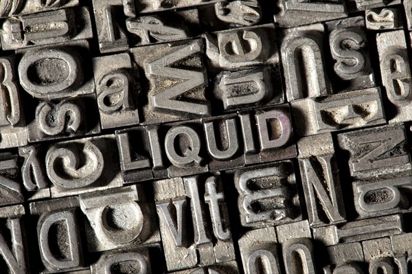 Old lead letters forming the word 'LIQUID'