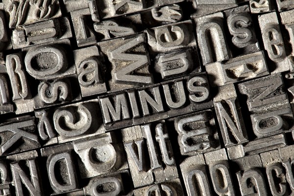 Old lead letters forming the word 'MINUS'