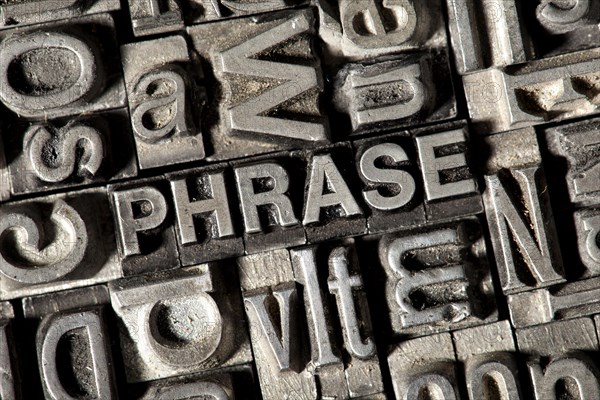 Old lead letters forming the word "PHRASE"