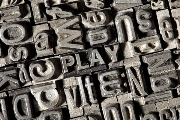 Old lead letters forming the word "PLAY"