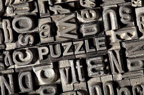 Old lead letters forming the word "PUZZLE"