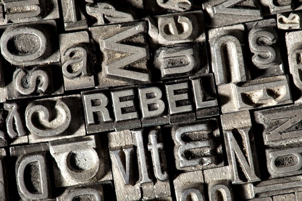 Old lead letters forming the word 'REBEL'
