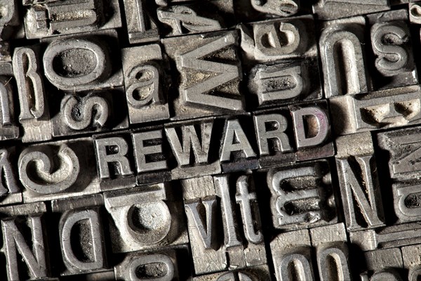 Old lead letters forming the word REWARD