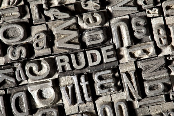 Old lead letters forming the word RUDE