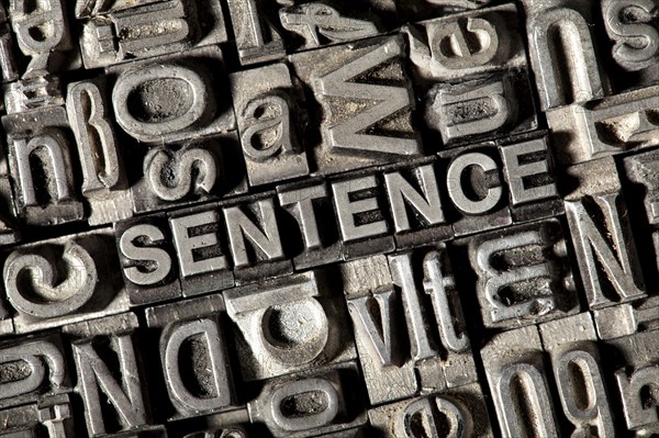 Old lead letters forming the word SENTENCE