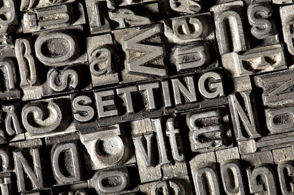 Old lead letters forming the word SETTING