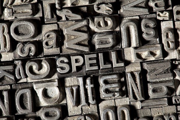 Old lead letters forming the word 'SPELL'