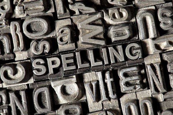 Old lead letters forming the word "SPELLING"