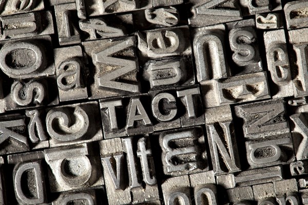 Old lead letters forming the word TACT