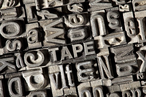 Old lead letters forming the word TAPE