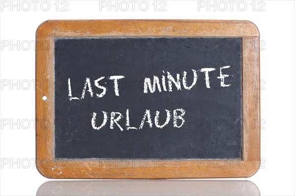 Old school blackboard with the words LAST MINUTE URLAUB