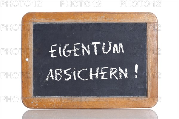 Old school blackboard with the words EIGENTUM ABSICHERN!