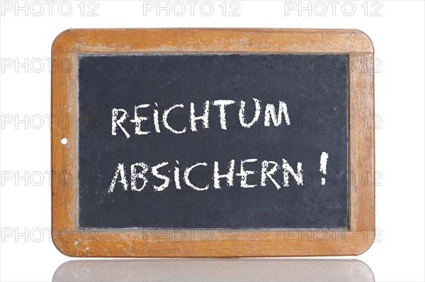 Old school blackboard with the words REICHTUM ABSICHERN!