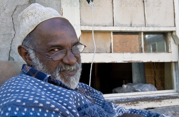 Man with glasses wearing a Kufi hat