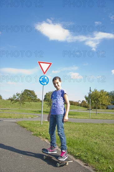 Girl riding a skateboard on a street