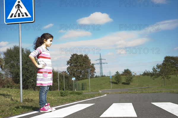 Girl waiting at a zebra crossing