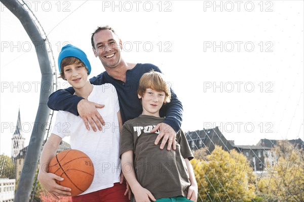 Two cool boys standing with their father on a playground