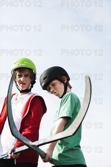 Two cool boys playing roller hockey with hockey sticks