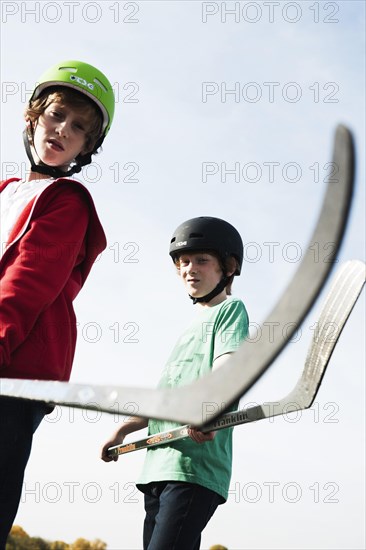 Two cool boys playing roller hockey with hockey sticks