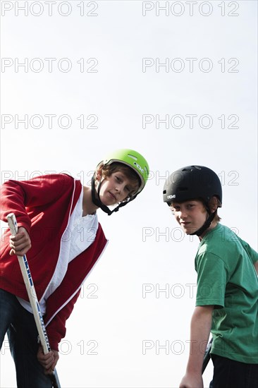 Two cool boys playing roller hockey with hockey sticks