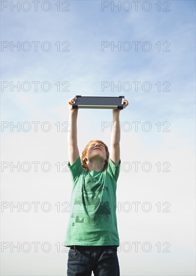 Boy holding a solar panel towards the sun