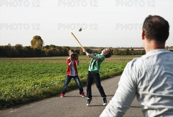 Father playing baseball with his sons