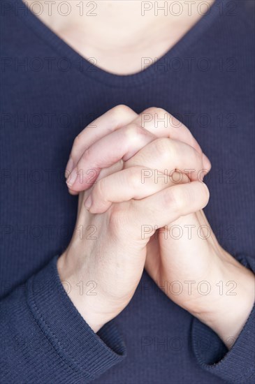 Woman praying with her hands clasped