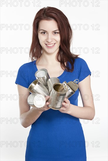 Young woman recycling tin cans