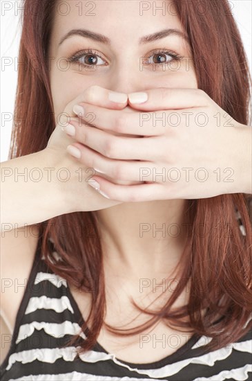 Young woman covering mouth with hands