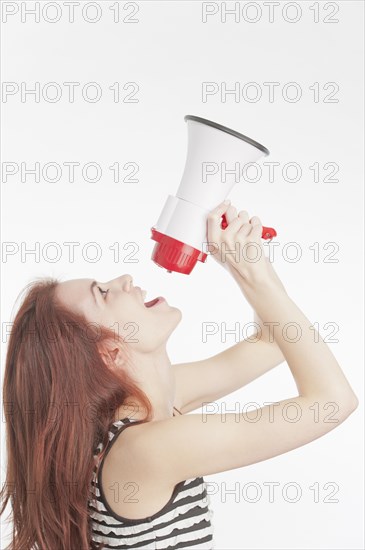 Young woman shouting in a megaphone