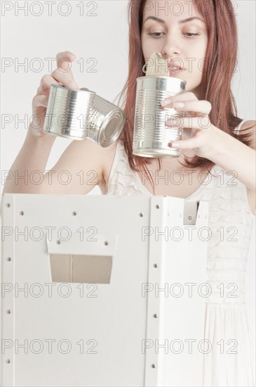 Young woman recycling tin cans