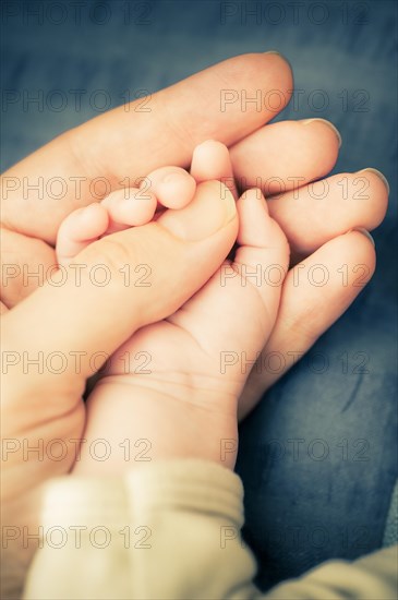 Hand of mother holding hand of baby