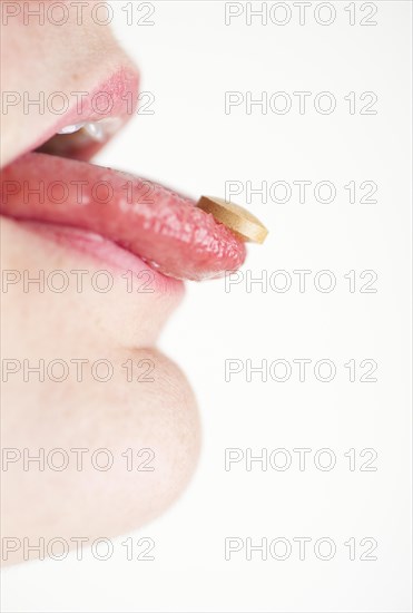 Woman with a pill on her tongue