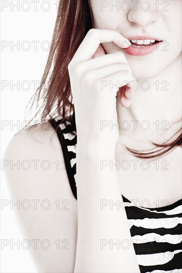 Young woman biting her fingernail