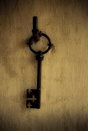 Old large key hanging on a wall