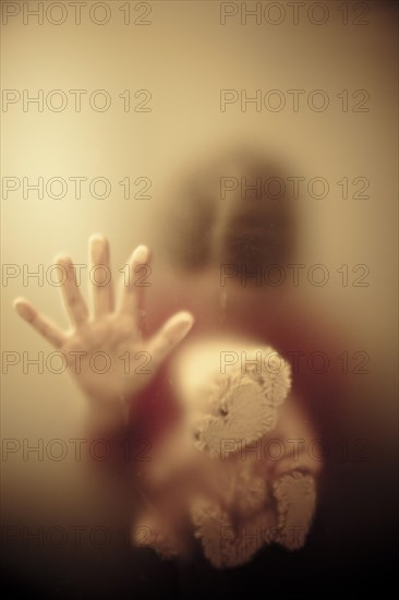 Woman looking down and holding a teddy bear