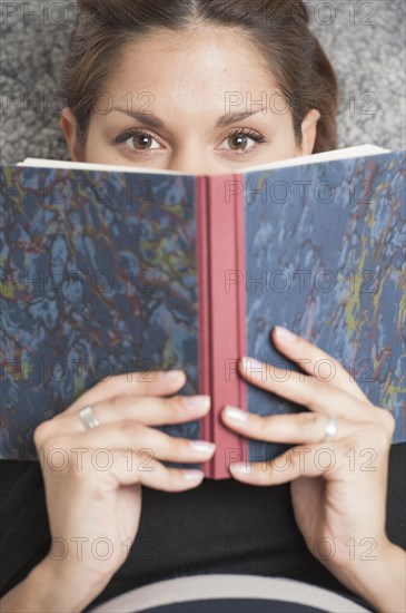 Woman lying in lounge chair and reading a diary