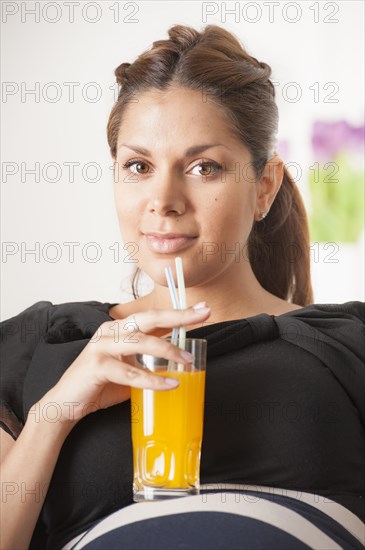 Pregnant woman drinking a glass of orange soda