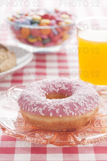 Donut with sprinkles and a glass of orange soda