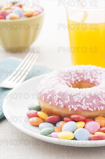 Donut with sprinkles and a glass of orange soda