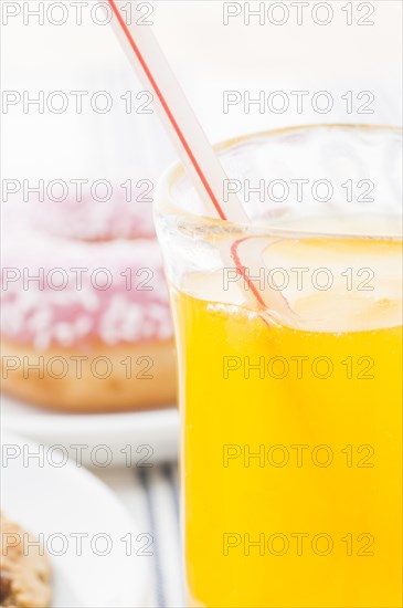 Glass of orange soda with drinking straw