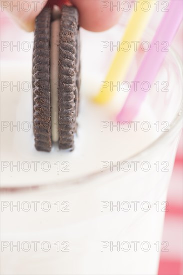 Dunking a chocolate cookie in a glass of milk