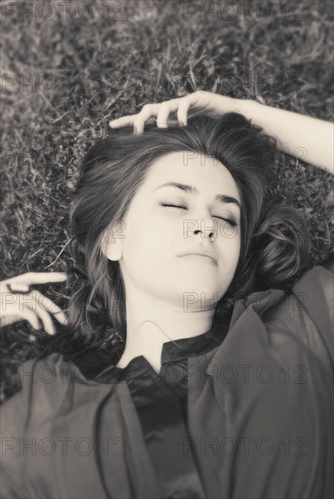 Young woman with closed eyes lying on grass