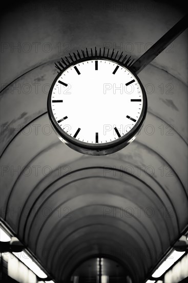 Empty clockface in a deserted walkway tunnel