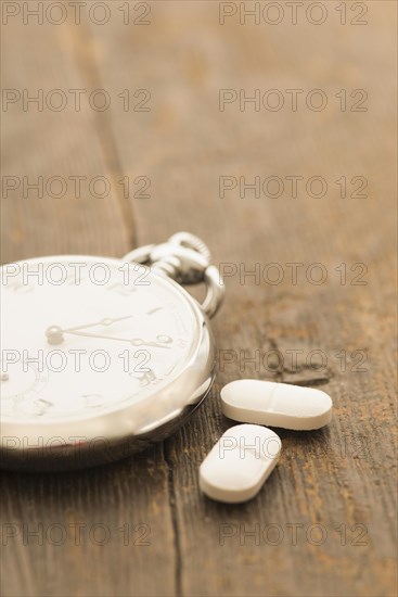 Two capsules next to retro pocket watch