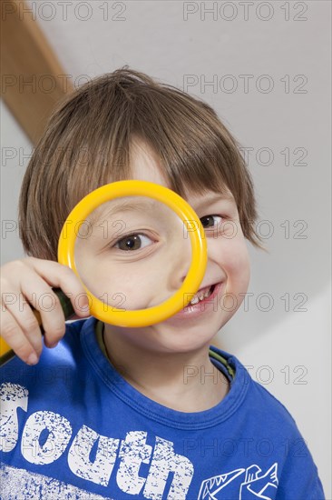 Boy looking through a magnifying glass