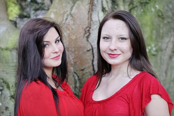 Two sisters in front of an old tree