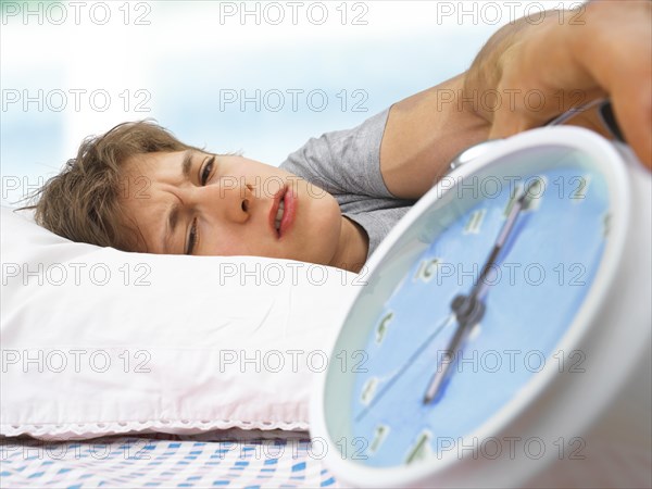 Young man with an alarm clock