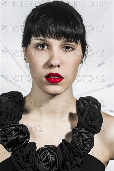 Young woman in black dress with fabric roses