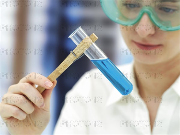 Scientist wearing a protective mask and holding a test tube